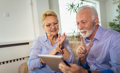 Two people using sign language over an ipad video chat.