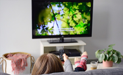 Child watching television with subtitles on.